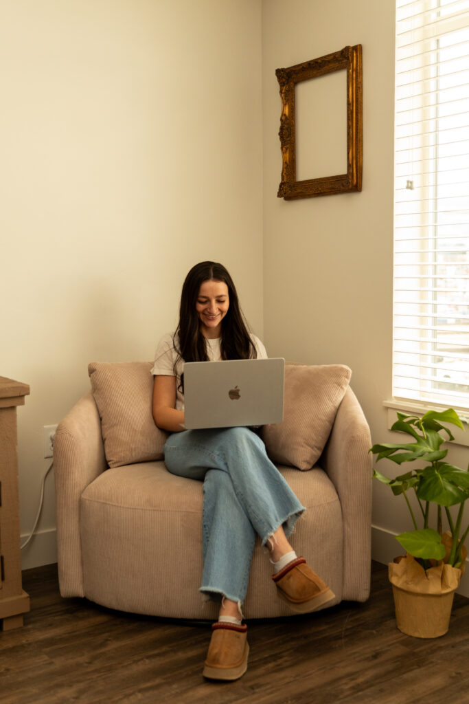 Abi works on her laptop to create refined logo ideas for interior designers building a cohesive visual brand system. 